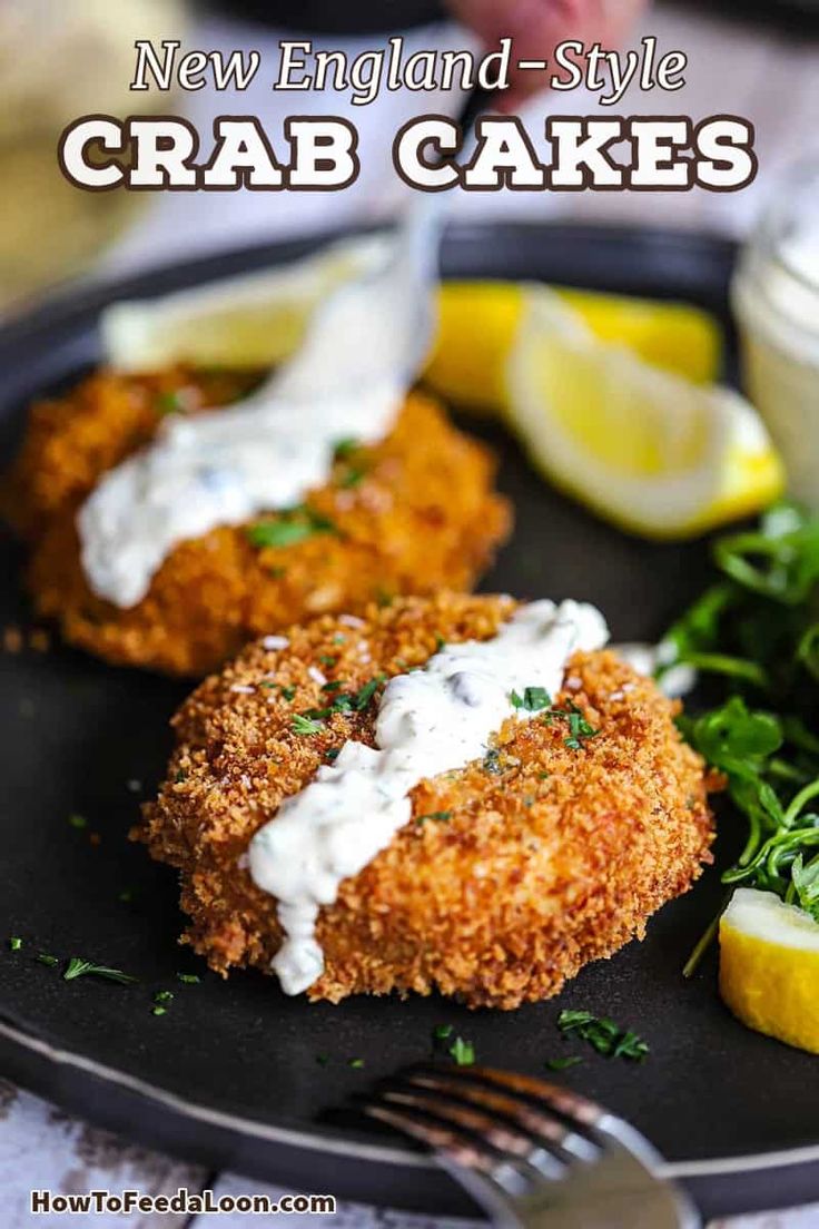 crab cakes on a black plate with lemon wedges and parsley garnish