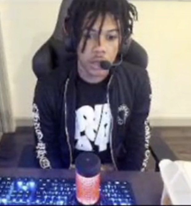 a man with dreadlocks sitting in front of a computer keyboard