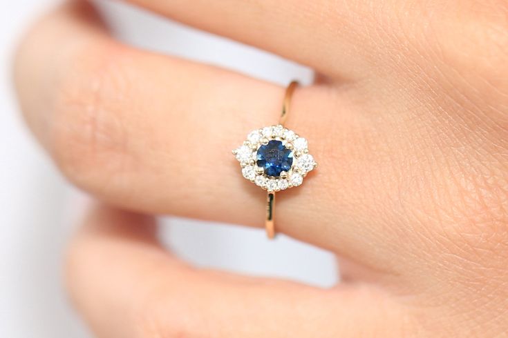 "Sapphire Ring / 14k Gold Round Sapphire Halo Wedding Ring / Halo Engagement Ring / September Birthstone Ring / Wedding Gold Diamond Ring Item Details * Made to Order * Gold Kt: 14K Solid Gold * Custom Gold Color: Rose Gold, Yellow Gold, White Gold * Round Diamond: 2 pcs pc 2.00MM * Round Diamond: 4 pc 1.75MM * Round Diamond: 6 pc 1.25MM * Round Sapphire: 1 pc 5MM * Total Number of Stones: 6 * Total Diamond CTW: 0.21 Ctw * Total Sapphire CTW: 0.40 Ctw * Diamond Color-Clarity: G Color Si1 Clarity Rose Gold Sapphire Ring For Wedding, Exquisite Cluster Diamond Wedding Ring, Exquisite Cluster Diamond Ring For Wedding, 14k Gold Round Cut Cluster Wedding Ring, Delicate Round Cut Cluster Ring For Anniversary, Dainty Round Halo Setting Wedding Ring, Elegant Gold Sapphire Ring For Wedding, Gold Sapphire Diamond Ring With Halo Design, Elegant Gold Sapphire Wedding Ring