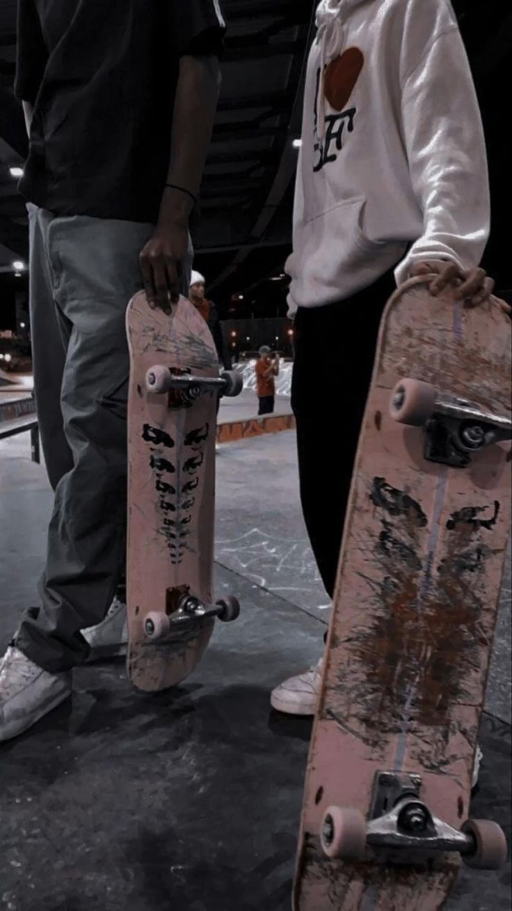 two people holding skateboards in their hands