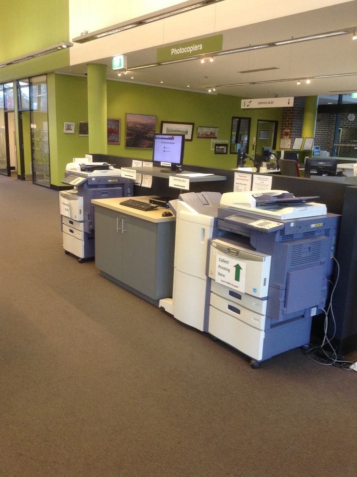 an office filled with lots of computers and printer's