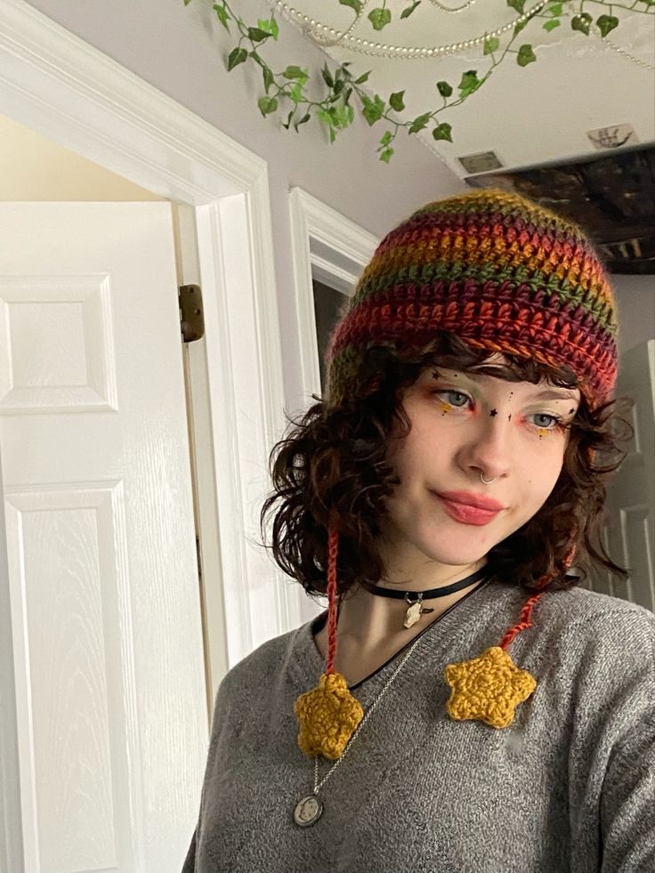 a young woman wearing a knitted hat and necklace