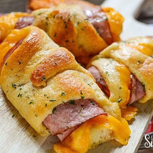 ham and cheese crescent pastries on a cutting board