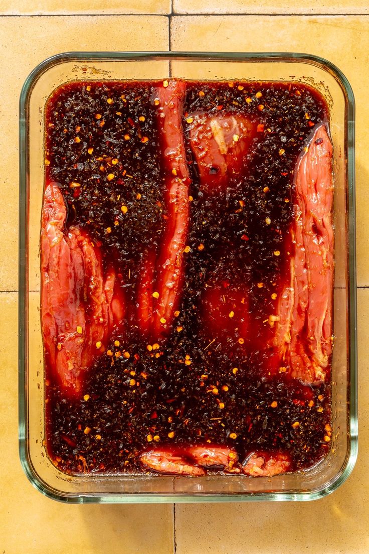 meat in a glass dish on a tiled surface