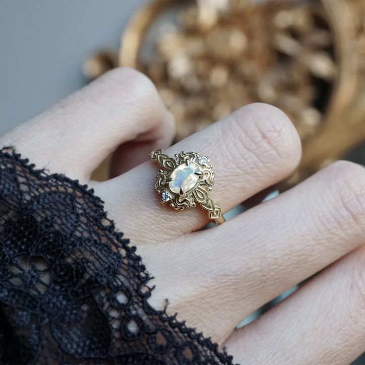 Read about our payment plans before proceeding. In the heart of this exquisite Faith ring, a magical moonstone with a blue sheen nestles, a gem of nature's tender artistry. Embraced by delicate scroll-like motifs, each curve whispers tales of timeless elegance, bestowing upon it a vintage flair that dances with the echoes of ages past. Crafted by skilled hands, this ring is available in your choice of 14K and 18K yellow gold, rose gold, and white gold. All orders come in our Tippy Taste ring box Yellow Gold Brass Moonstone Ring For Gift, Heirloom Moonstone Ring With Rose Cut Diamonds For Promise, Heirloom Style Moonstone Ring With Rose Cut Diamonds, Heirloom Moonstone Ring With Rose Cut Diamonds, Handmade Yellow Gold Moonstone Ring Fine Jewelry, Handmade Fine Jewelry Yellow Gold Moonstone Ring, Handmade Yellow Gold Moonstone Ring, Heirloom Gold Opal Gemstone Ring, Heirloom Style Moonstone Open Ring