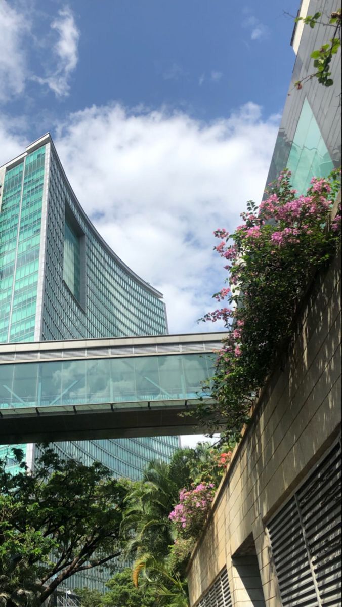 a tall building sitting next to a lush green forest