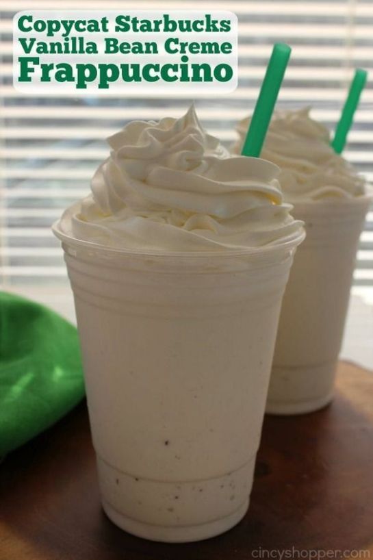 two cups filled with whipped cream on top of a table