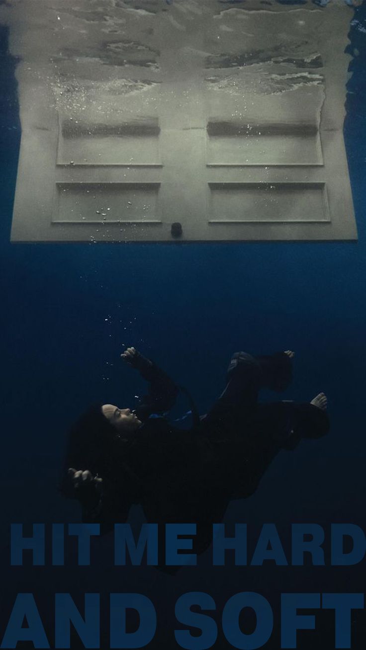 a man swimming under the water in front of a white box with words on it that reads hit me hard and soft