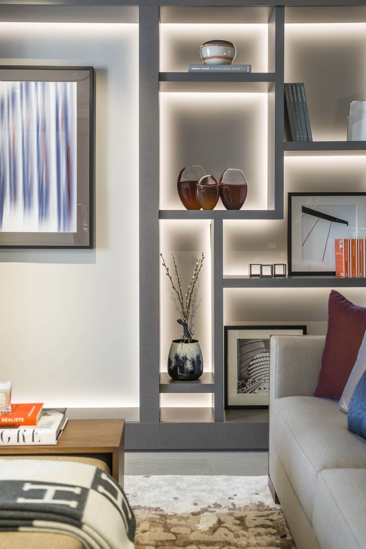 a living room filled with furniture and bookshelves next to a wall mounted tv