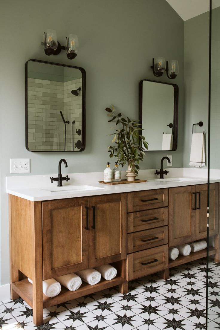 a bathroom with two sinks and mirrors on the wall next to a tiled floor that has black and white tiles