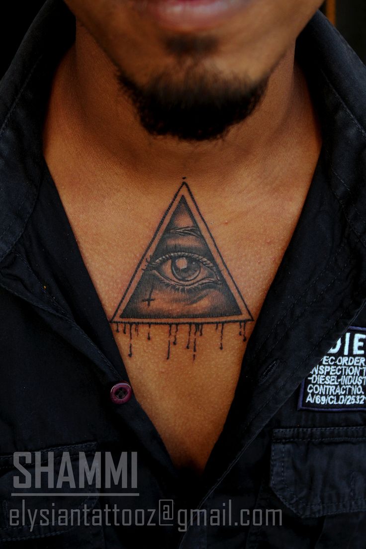 a close up of a man's chest with an all seeing eye tattoo on it