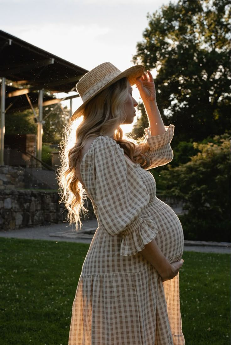 a pregnant woman in a dress and hat