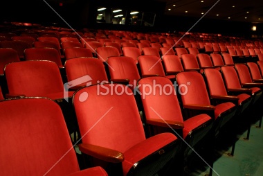 rows of red chairs in an empty auditorium