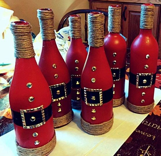 six red wine bottles decorated with gold and black decorations