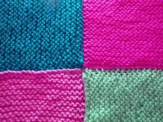 four different colors of knitted material are shown in this image, one is blue and the other is pink