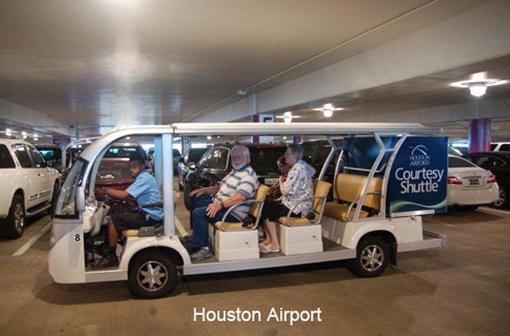 two men in a golf cart at the courtys suite houston airport with other cars behind them