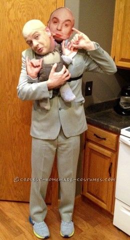 a man holding a baby in his arms while standing next to a stove top oven