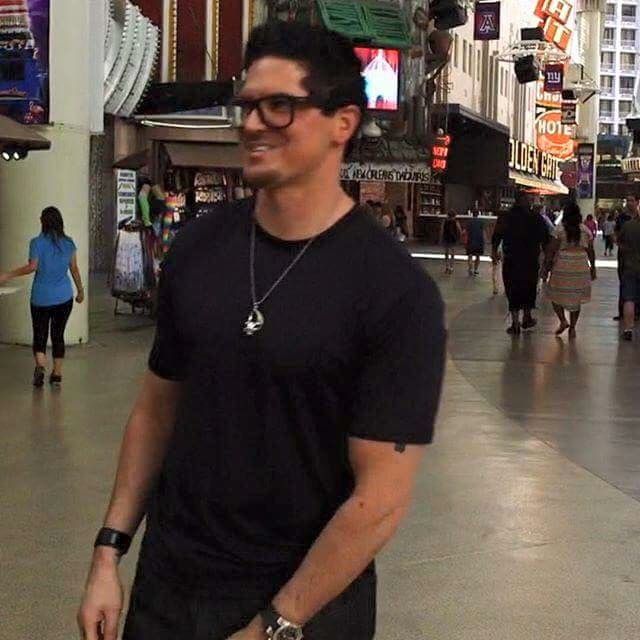 a man standing in the middle of a mall with his hand on his hip and smiling at the camera