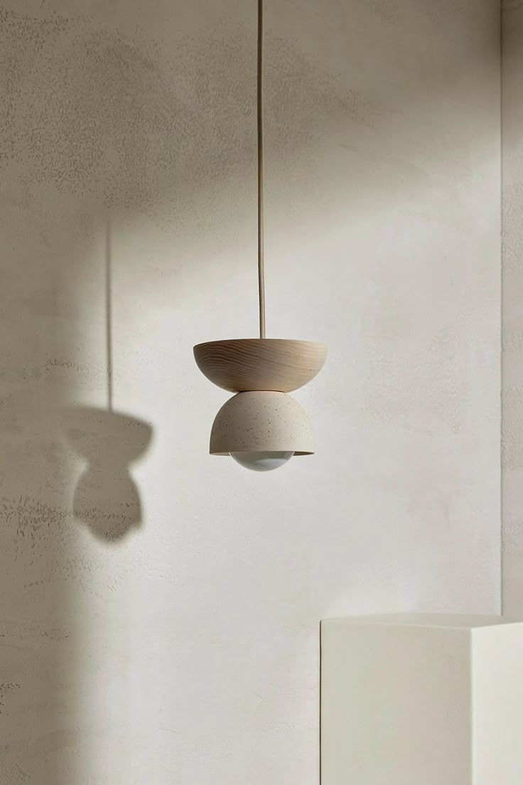 two light fixtures hanging from the ceiling in a room with white walls and flooring