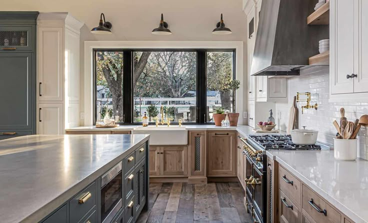 a kitchen with wooden cabinets and marble counter tops, along with an island in the middle