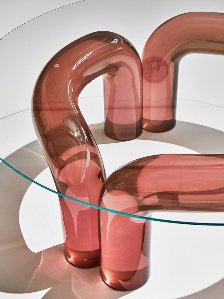 a glass table topped with two pink vases on top of it's sides