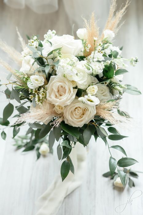 a bridal bouquet with white flowers and greenery