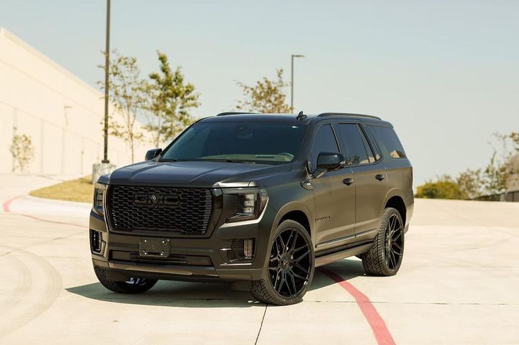 the front end of a black suv parked in a parking lot