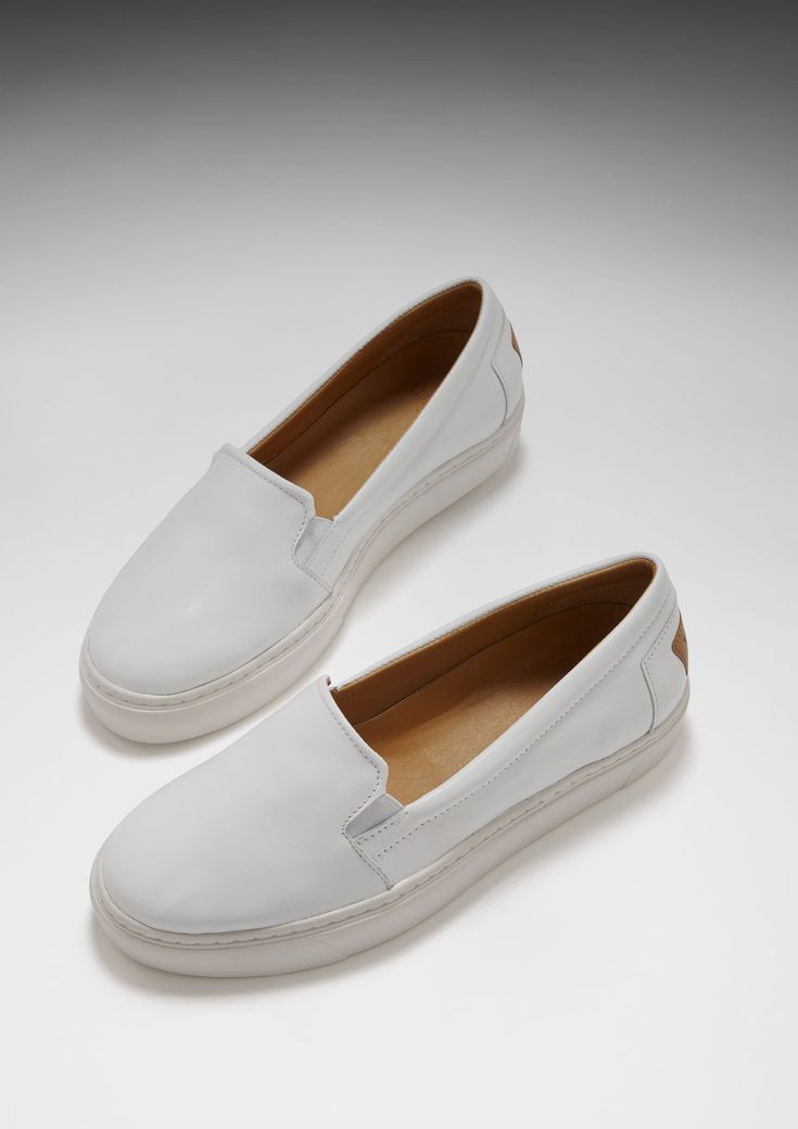 Slip-on contemporary style sneakers for women in white leather by Hugs & Co. Ultimately comfortable sneakers with a white leather upper and crisp white Vibram sole. Featuring our signature full leather lining for luxurious comfort and long lasting shape. Made in Portugal 100% Leather Upper featuring a 100% Leather Lining Rubber sneaker sole by Vibram White Leather Slip-ons With Stitched Sole, White Sporty Slip-ons With Rubber Sole, Sporty White Slip-ons With Rubber Sole, White Slip-ons With Perforated Toe Box, White Classic Slip-on Sneakers With Round Toe, Classic White Slip-on Sneakers With Textured Sole, Casual White Leather Slip-ons, White Low-top Slip-ons With Removable Insole, White Low-top Slip-on Sneakers With Removable Insole