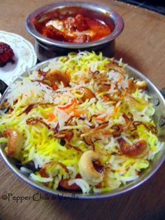 two bowls filled with food sitting on top of a wooden table next to other dishes