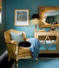 a room with blue walls and gold furniture