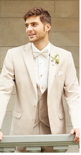 a man in a tuxedo is standing by a railing and looking off into the distance