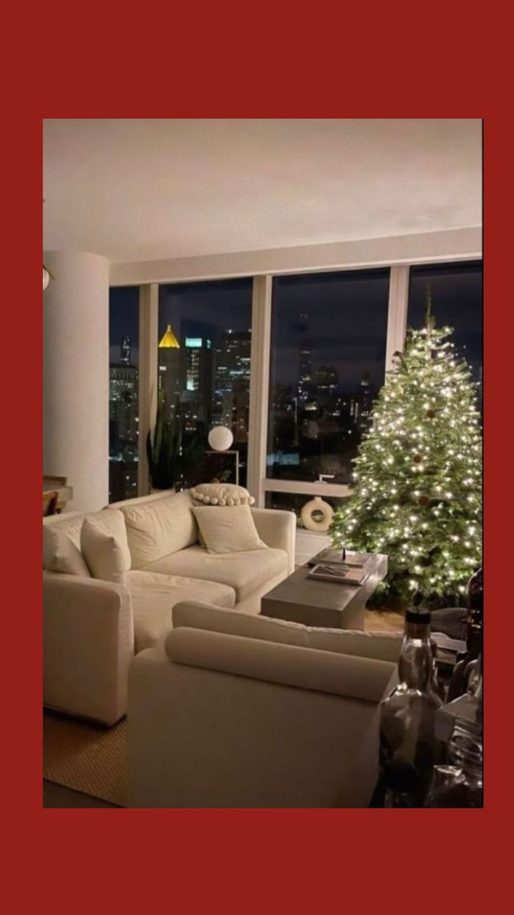 a living room filled with white furniture and a christmas tree in the middle of it