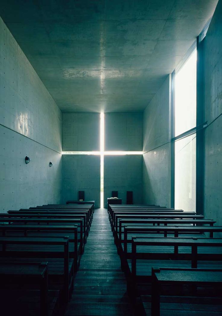 an empty church with rows of pews in front of a cross on the wall