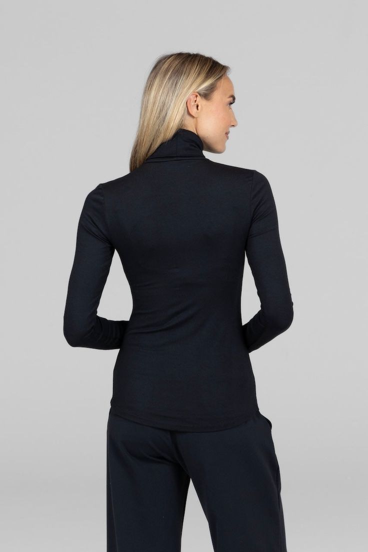 Why we love this: Elevate your winter style with our Black Turtleneck Sweater. Crafted with a cozy blend of comfort and sophistication, this versatile wardrobe staple is perfect for layering or wearing solo, ensuring a timeless and chic look. Features: KiraGrace Luxe: Feels soft and luxurious Close-fitting, ultra soft, and smooth Long sleeve with thumbhole details Transitions from studio to street Turtleneck design Made in U.S.A. of imported fabric FIT: Form-fitting, hip-length hem that stays pu Cozy Stretch Tops For Work, Fitted Black Turtleneck Outerwear, Black Fitted Turtleneck Outerwear, Winter Athleisure Fitted Tops, Cozy Black Stretch Outerwear, Black Stretch Turtleneck Outerwear, Cozy Stretch Black Tops, Black High Stretch Funnel Neck Top, Black Turtleneck For Winter Layering