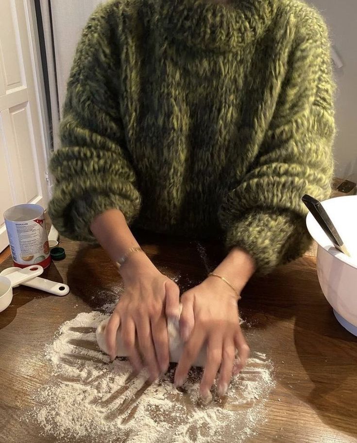 a woman is kneading dough on a table