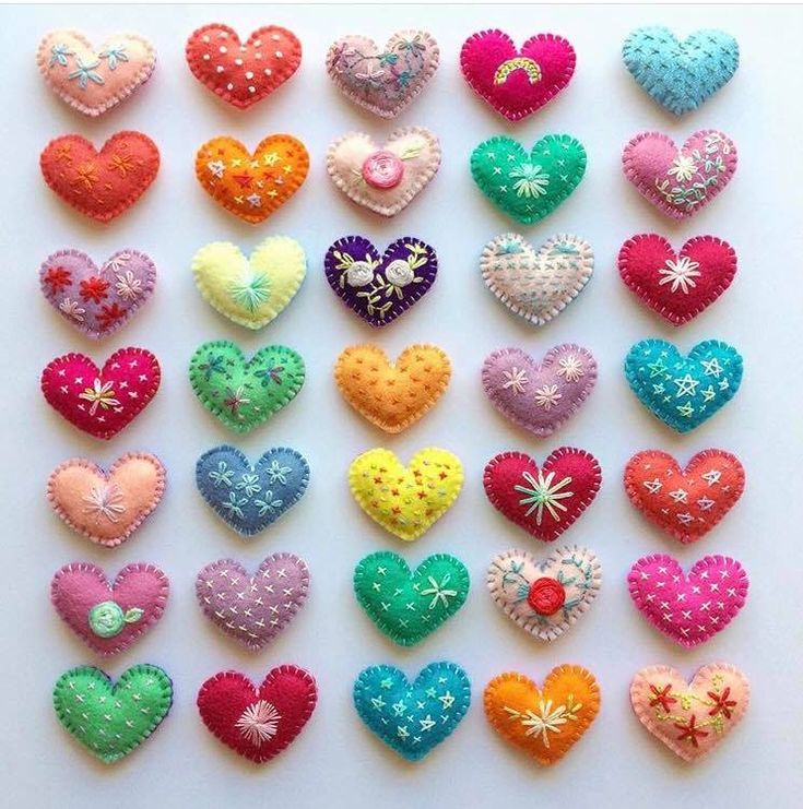 many different colored hearts are arranged on a white surface