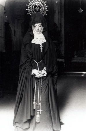 an old black and white photo of a woman wearing a nun outfit with a crown on her head