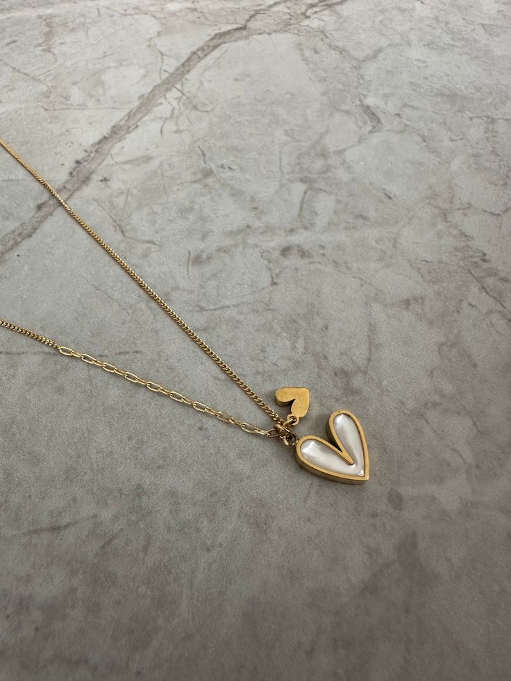 The double heart necklace features a white pearlescent heart and a little gold heart next to it. Perfect for gifting! Measurements: Height: 1.1cmWidth: 1.3 cm Gold Heart Necklaces With Pearl Charm, White Heart Necklace With Pearl Pendant, Gold Heart Necklace With Pearl Charm As Gift, Gold Heart Necklace With Pearl Charm For Valentine's Day, Everyday Heart Shaped Necklace With Pearl Charm, Trendy Heart-shaped Necklace With Pearl Charm, Everyday Heart-shaped Necklace With Pearl Charm, Everyday Heart-shaped Pearl Charm Necklace, Dainty White Heart Pendant Necklace