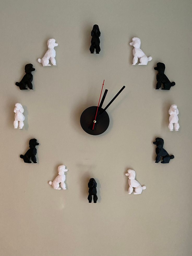 a clock made out of small black and white figurines on a gray surface