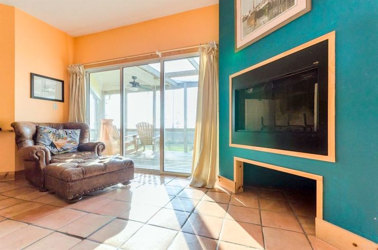 a living room filled with furniture and a flat screen tv mounted on a wall next to a fire place