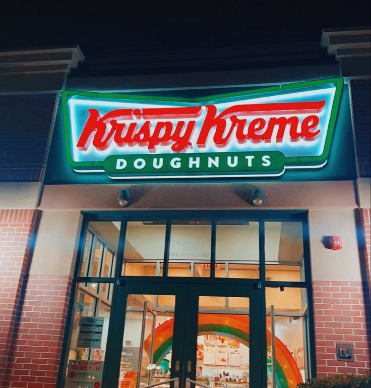 krispy kreme doughnuts is lit up at night