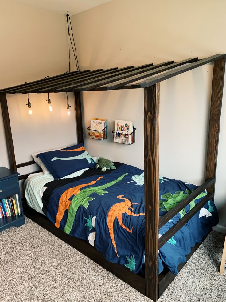 a bed with a canopy made out of wood and blue bedspread on top of it