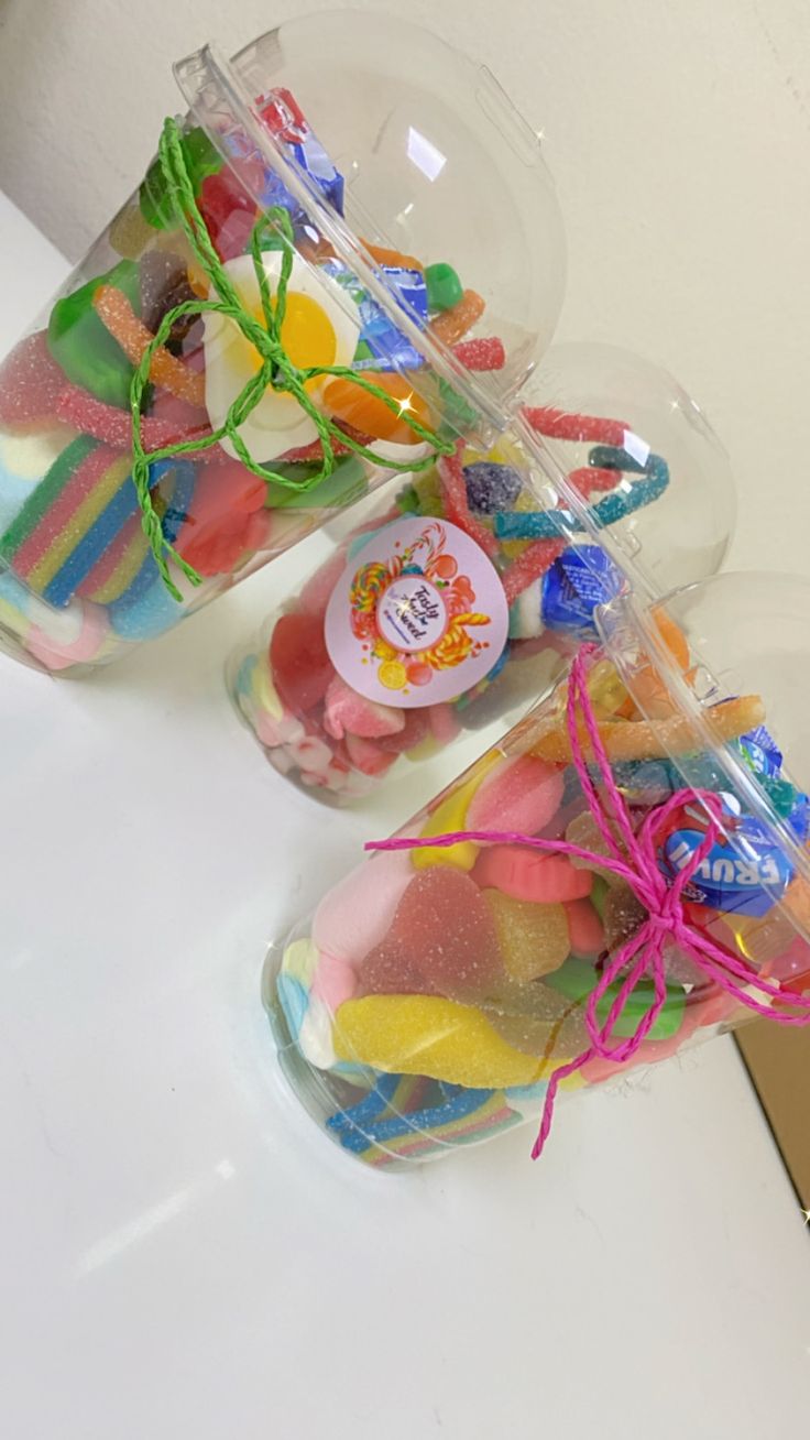 two clear vases filled with candy and candies