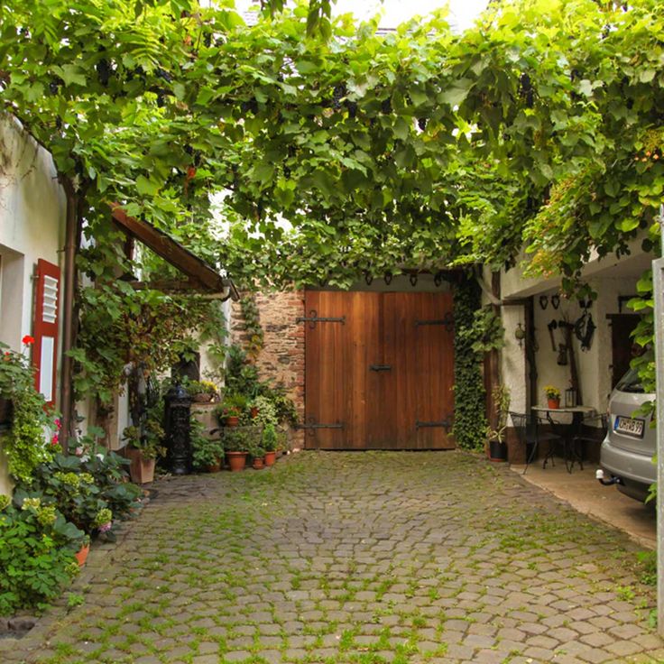 a car is parked in front of a house with vines growing on the roof and doors