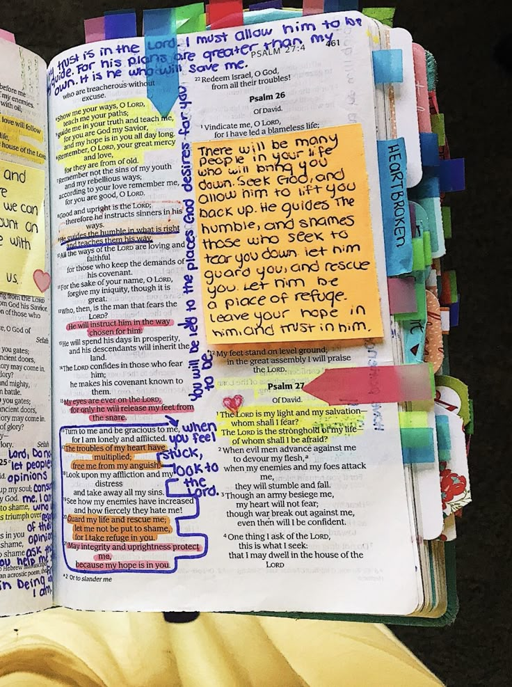 an open bible with colorful sticky notes on the pages and words written in different languages