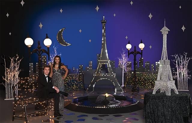 a man and woman posing in front of the eiffel tower at christmas time