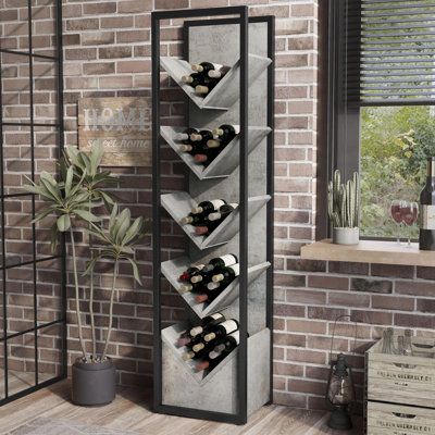 a wine rack with bottles in it next to a brick wall and potted plant