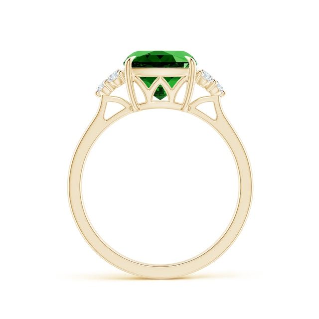 an emerald and diamond ring with three diamonds on the shoulders, set in yellow gold