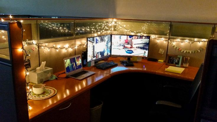 an office cubicle decorated with christmas lights and computer screens