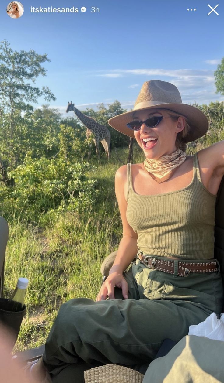 a woman sitting on the back of a safari vehicle